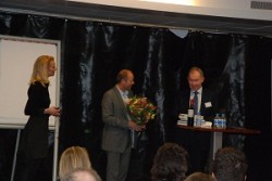 Gerard Struijf (m) draagt de rol van voorzitter over aan René de Zoete (r). Maricken Hengeveld (l) opende de Kennissessie met een korte introductie over PvKO